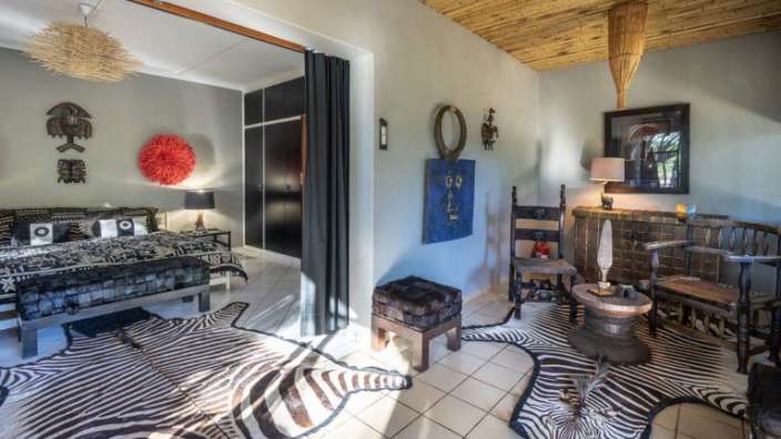 Ein Schlafzimmer mit einem Bett und einem Zebrateppich