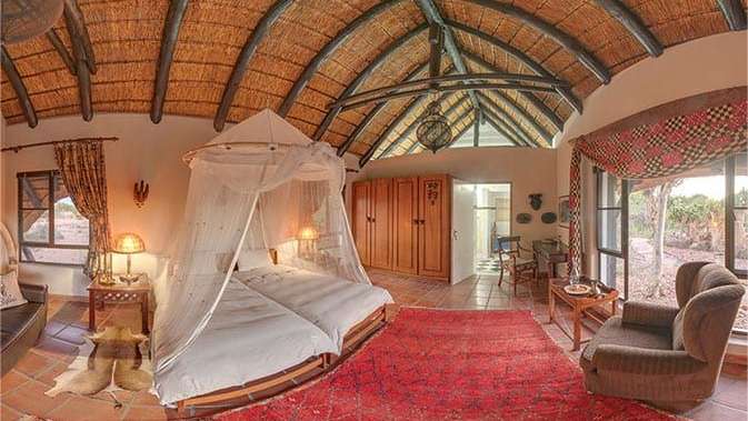 Ein Schlafzimmer mit Strohdach und zwei Betten