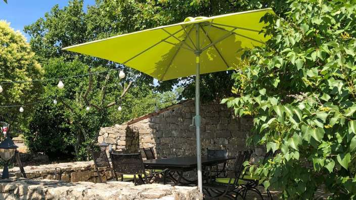 Ein Tisch und Stühle unter einem gelben Sonnenschirm