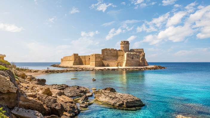 Ein großes Schloss sitzt auf einer kleinen Insel im Ozean