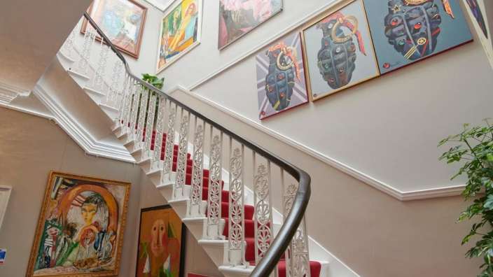 Eine Treppe mit vielen Gemälden an der Wand