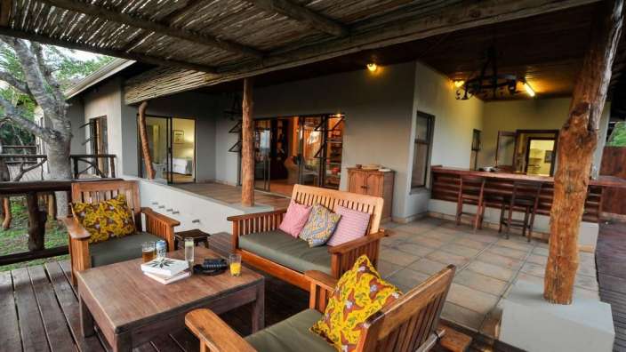 Eine Terrasse mit einem Tisch und Stühlen und einer Bar