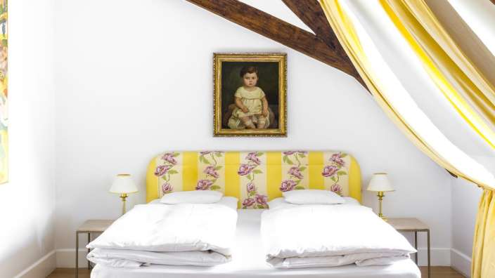 Ein Schlafzimmer mit einem Bett und einem Gemälde an der Wand
