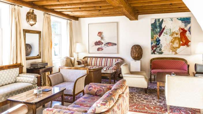 Ein Wohnzimmer mit vielen Möbeln und einem Gemälde an der Wand