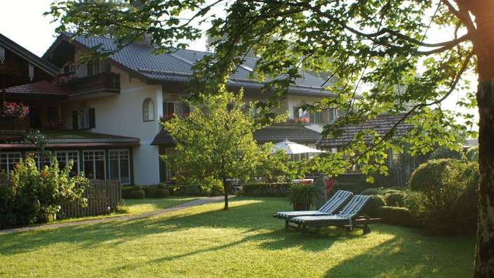 Liegestühle stehen auf einem grünen Rasen vor einem Haus