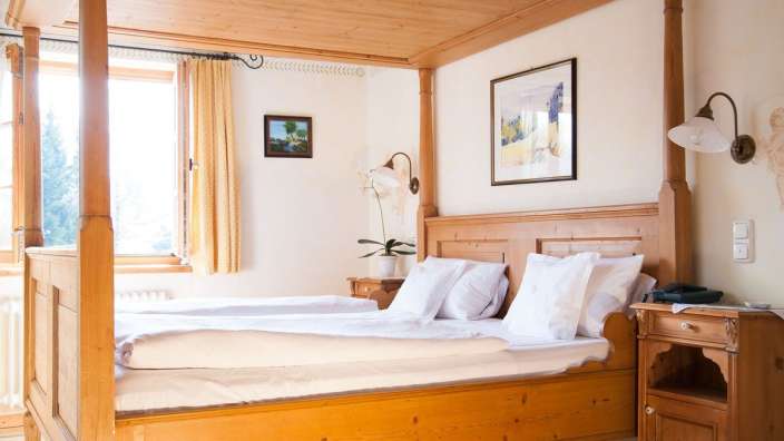 Ein Schlafzimmer mit einem Himmelbett und einem Gemälde an der Wand