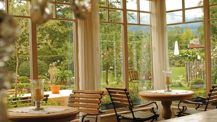 Ein Tisch und Stühle in einem Raum mit vielen Fenstern