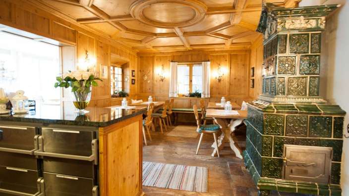 Ein Esszimmer mit Tisch und Stühlen und einem grünen Ofen