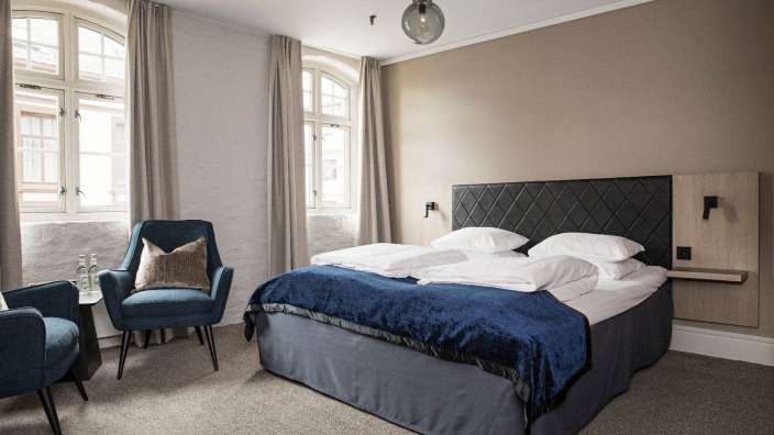 Ein Hotelzimmer mit einem Bett und zwei Stühlen