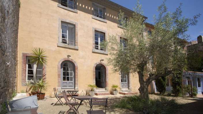 Ein Gebäude mit einem Tisch und Stühlen vorne