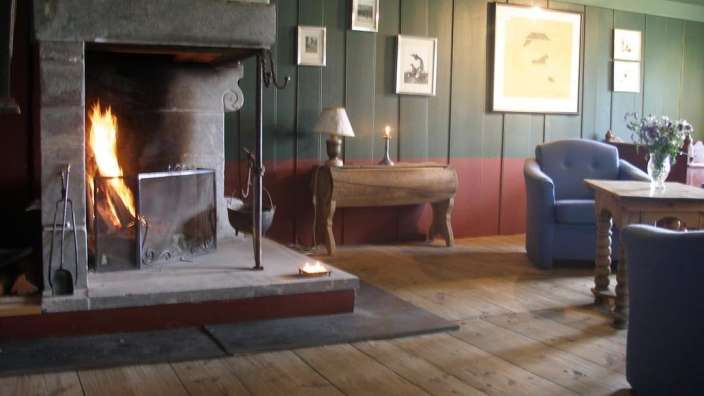 Ein Wohnzimmer mit einem Kamin und einem Tisch