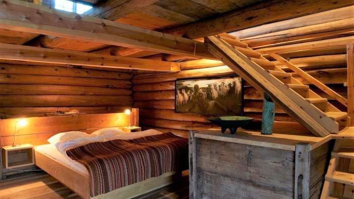 Ein Holzschlafzimmer mit einem Bett und einer Treppe