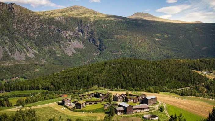 Ein kleines Dorf auf einem Hügel mit Bergen im Hintergrund