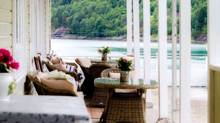 Tisch und Stühle auf einer Veranda mit Blick auf einen See