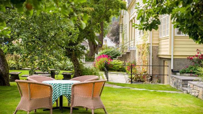 Ein Tisch und Stühle auf einem grünen Rasen vor einem Haus