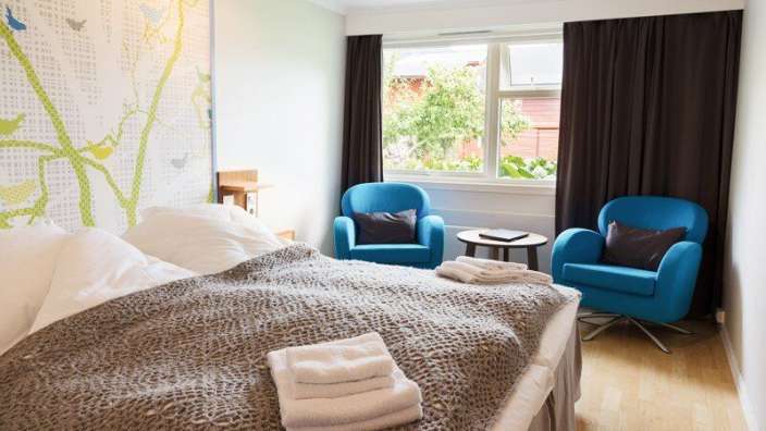 Ein Hotelzimmer mit einem Bett und zwei Stühlen