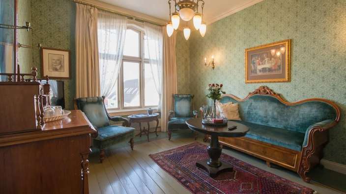 Ein Wohnzimmer mit einer Couch und zwei Stühlen