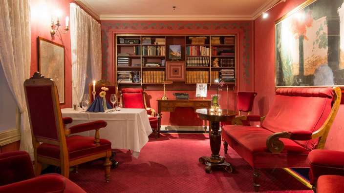 Ein Wohnzimmer mit roten Möbeln und einem Bücherregal
