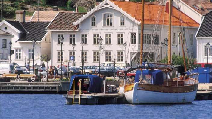 Ein weißes Boot sitzt an einem Dock in einem Hafen