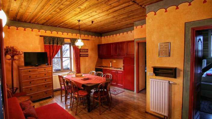 Ein Wohnzimmer mit einem Tisch und Stühlen und einem Fernseher