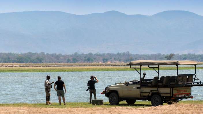 Eine Gruppe von Menschen steht neben einem toyota-Fahrzeug