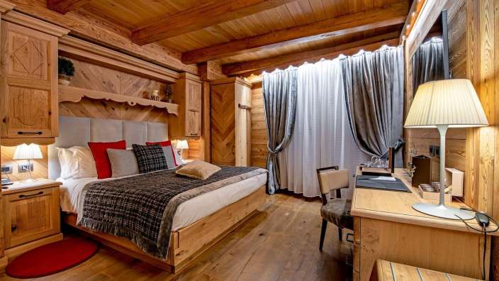 Ein Holzzimmer mit einem Bett und einem Schreibtisch