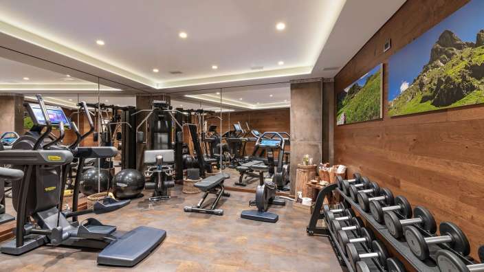 Ein Fitnessstudio mit vielen Geräten und Bildern an den Wänden