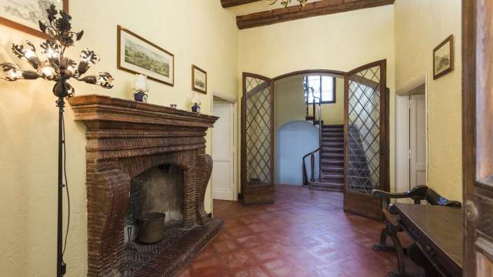 Ein Flur mit einem Kamin und einer Treppe