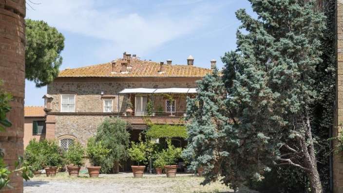 Ein großes Steingebäude mit einem Balkon und vielen Pflanzen in Töpfen