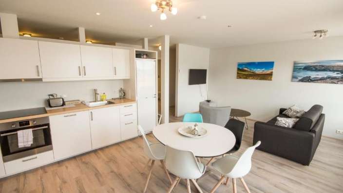 Eine Küche mit einem Tisch und Stühlen und einem Bild an der Wand