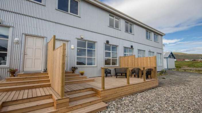 Ein weißes Gebäude mit einem Holzdeck davor