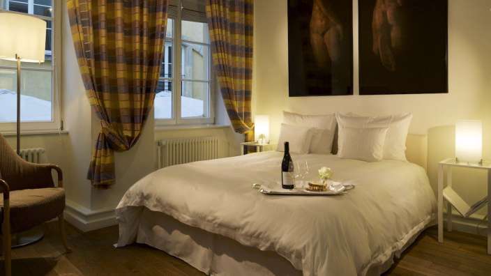 Ein Bett mit einer Flasche Wein und einem Tablett darauf