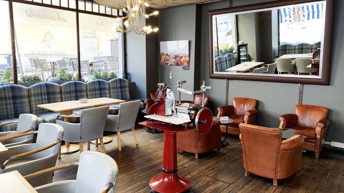 Ein Restaurant mit vielen Stühlen und Tischen und einem großen Spiegel