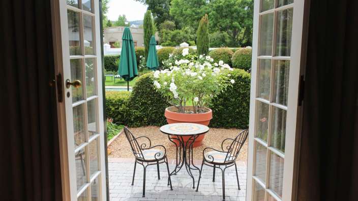 Eine Terrasse mit einem Tisch und Stühlen und einer Pflanze im Topf
