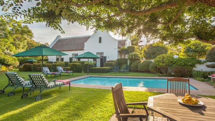 Ein Tisch und Stühle stehen neben einem Swimmingpool