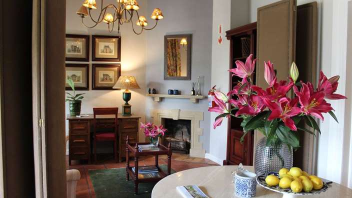 Ein Wohnzimmer mit einem Tisch und einer Vase mit Blumen darauf