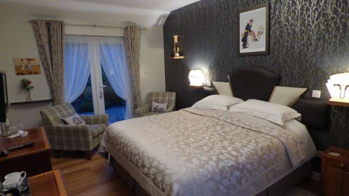 Ein Schlafzimmer mit einem Bett und zwei Stühlen