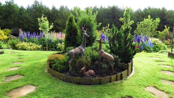 Eine Gruppe von Statuen von Hirschen in einem Garten