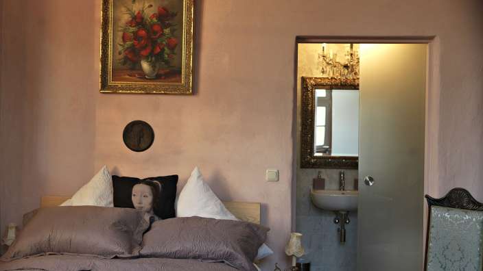 Ein Schlafzimmer mit einem Bett und einem Gemälde an der Wand