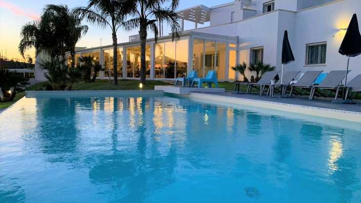 Ein großer Swimmingpool vor einem weißen Gebäude