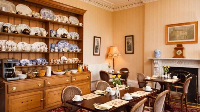 Ein Esszimmer mit einem Tisch und Stühlen und einem Buffet