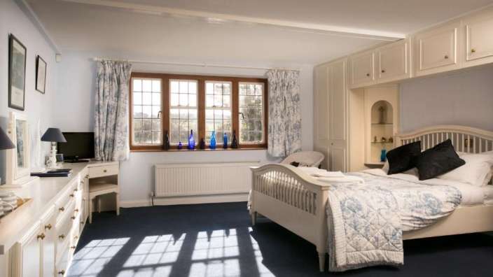 Ein Schlafzimmer mit einem Bett und vielen Fenstern