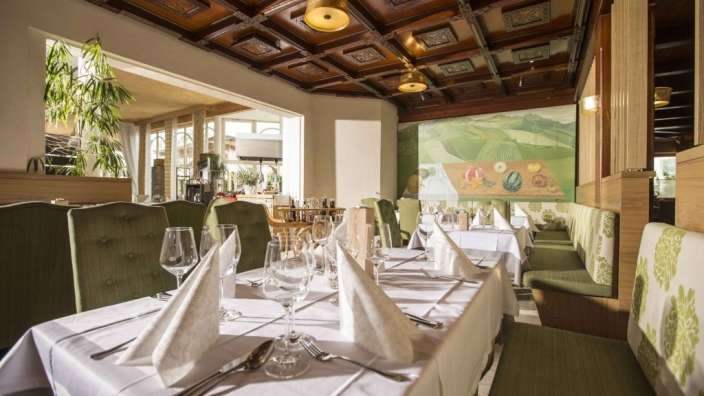 Ein Speisesaal mit Tisch und Stühlen und einem Gemälde an der Wand