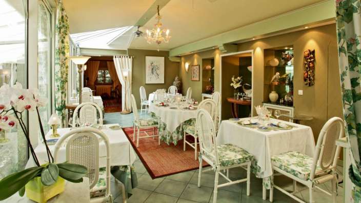 Ein Esszimmer mit vielen Tischen und Stühlen