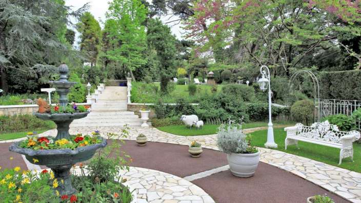 Ein Garten mit einem Brunnen und Blumentöpfen