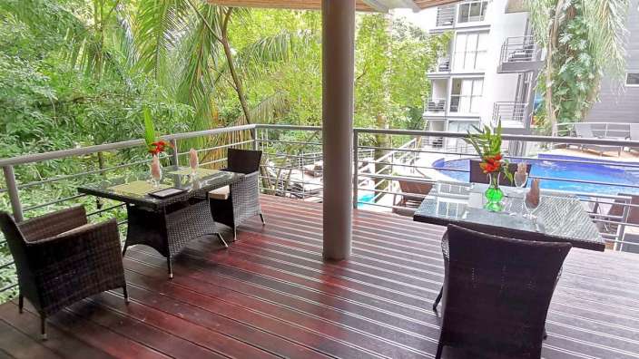 Ein Tisch und Stühle auf einem Deck mit Blick auf einen Pool