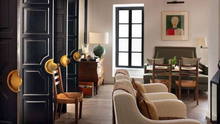 Ein Wohnzimmer mit schwarzen Türen und einem Gemälde an der Wand