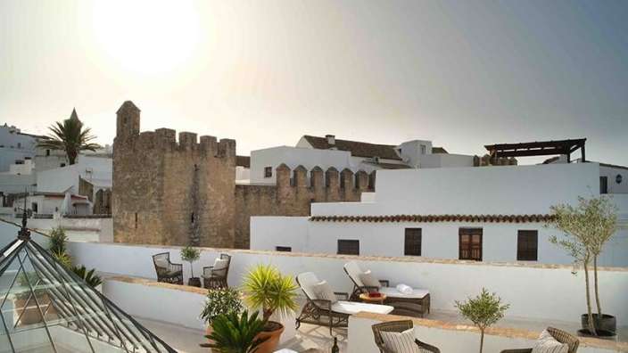 Ein weißes Gebäude mit einem Tisch und Stühlen darauf