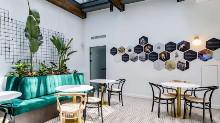 Ein Raum mit Tischen und Stühlen und einer Wand mit Bildern