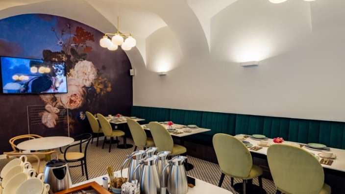 Ein Speisesaal mit Tischen und Stühlen und einem Fernseher